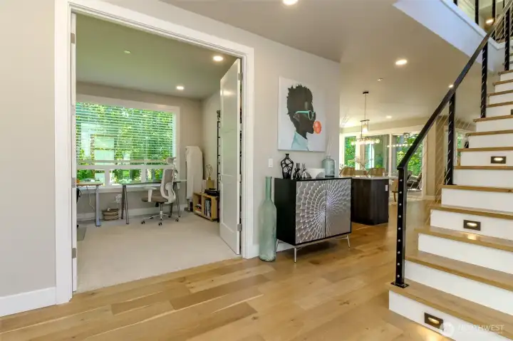 Open entry with a cool and refreshing feel with high ceilings and to the right is a wall of windows.  The staircase has modern open railing finish work with built in riser lighting.
