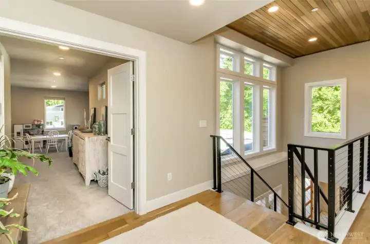 Second floor landing is very wide.  To the right is the primary bedroom hall in this picture and to the left, is the double door entry to the huge bonus room.