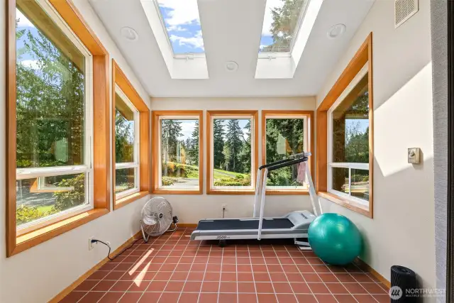 Sunroom with skylights and tile flooring.