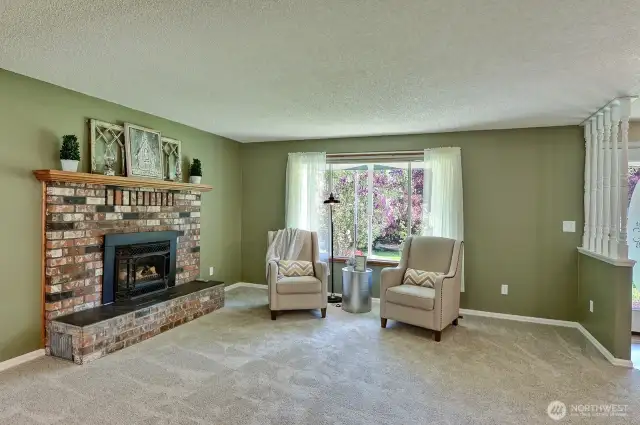 Front living room with fresh paint, carpet, and a cozy gas fireplace.