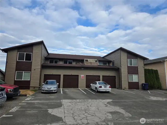 Rear of building with parking area.  Each unit has their garage space, spot behind the garage and one additional assigned space.
