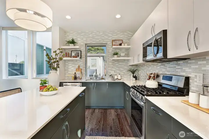 Kitchen features beautiful countertops and a gas range.