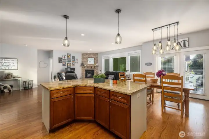 A view from the spacious kitchen, over the center island to the great room.  Granite countertops, lots of storage in the kitchen.  Island has seating.  Oak floors throughout the living area.