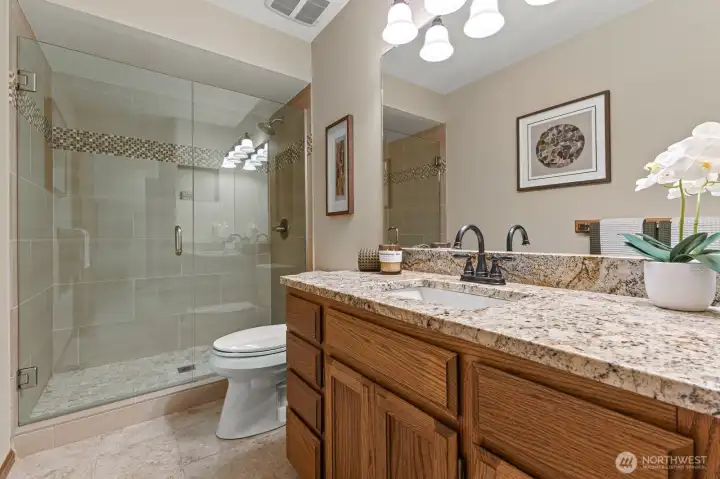 3/4 Lower Level bath has a stylish step-in, tiled shower and frameless glass shower doors.