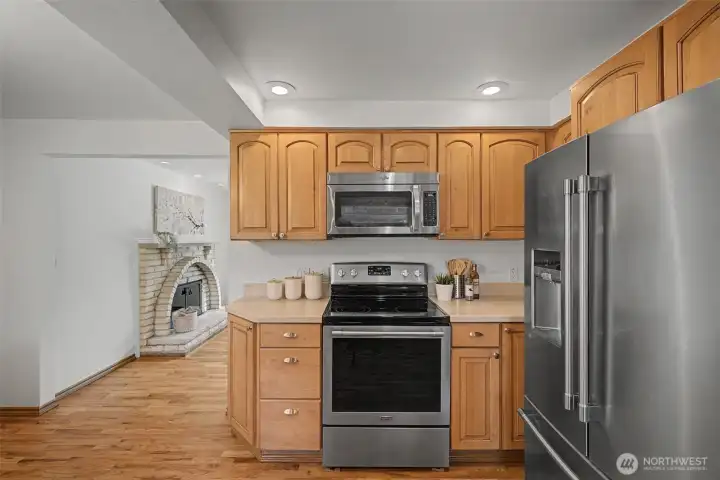 Kitchen with generous cabinetry, stainless appliances, and hardwood floors, open to the living room.