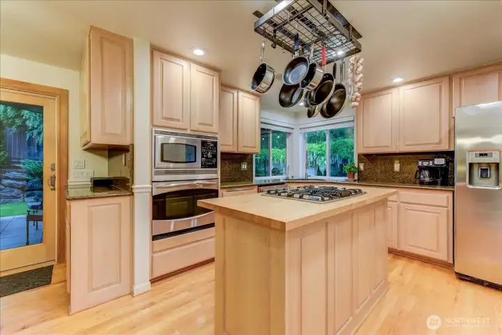 Built-in credenza providing additional storage and workspace, complemented by granite countertop that match the kitchen.