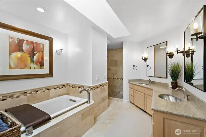 Primary bath with double sinks, large walk-in shower, large soaking tub, and walk in closet