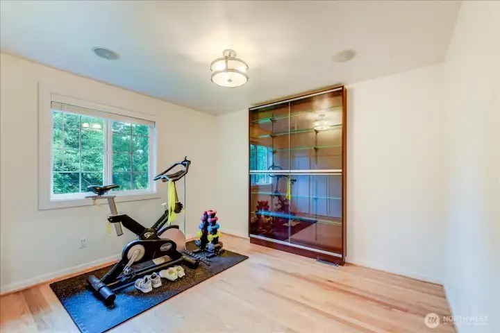 This bedroom is currently staged as a home office and exercise room; the built-in cabinets will remain with the property.