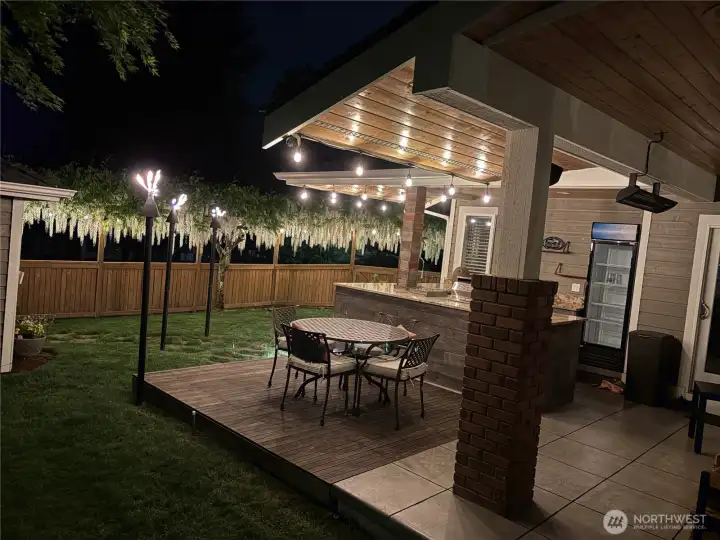 Gas-plumbed tiki torches and integrated outdoor lighting enhance this exceptional entertaining space.