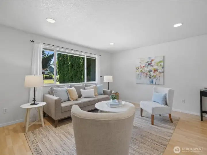 The living room is light and pleasant, with inset lighting and large window.