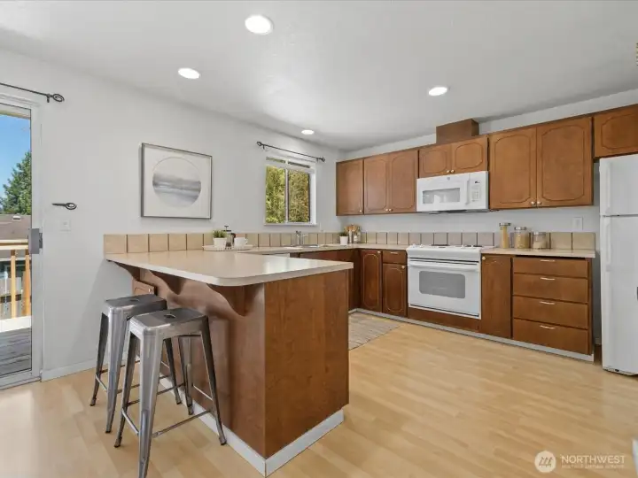 Convenient breakfast bar in the kitchen. Very generous counters, cabinetry, work space and pantry.