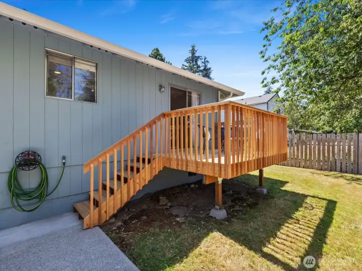The backyard is partially fenced and features a patio and newly re-built deck.