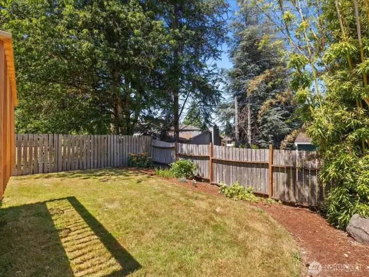 Level, sunny backyard perfect for play, gardening, entertaining.