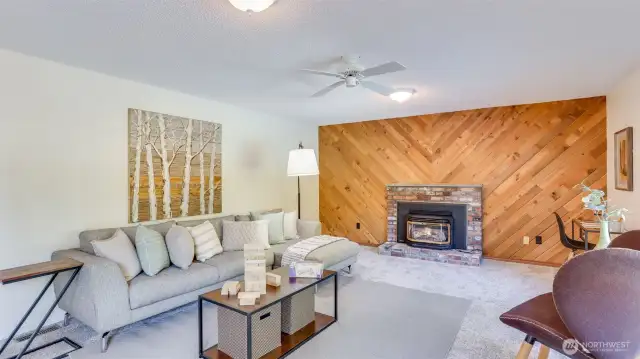 This cozy living room features a wood wall, gas fireplace, brand new carpets and views to the backyard!