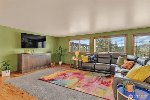 Family room with lush carpet inlay. Wall of windows showcasing the beautiful property and Mt. Rainier views.