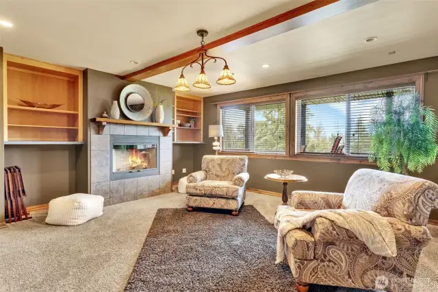 Just off the kitchen is the formal living room or game room you choose. The wall of windows showcase the backside of the property and stunning Mt. Rainier.