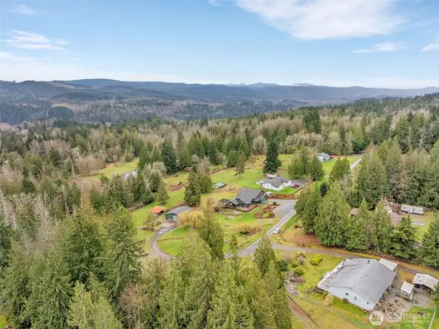 This aerial view showcases the property and road to detached shop/garage.