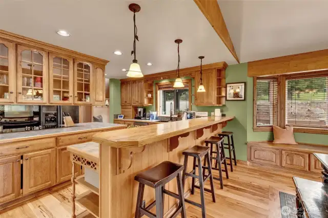 Breakfast bar easily accommodates four barstools. Bay window with seating and storage bench.