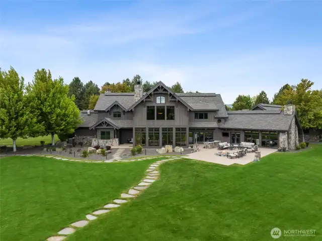 The back of the home has a 2,230 sq ft patio and outdoor kitchen with grill, sink and storage along with a natural gas fire pit and lanterns. Home has a new Rain Bird sprinkler system.