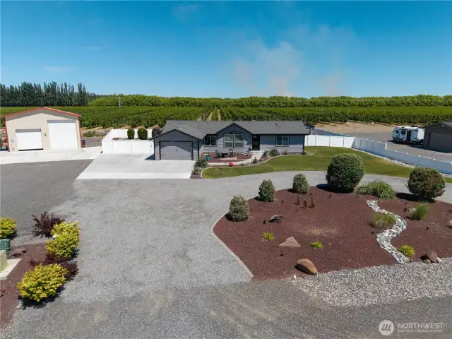 Aerial front of home with circular driveway and RV Parking.