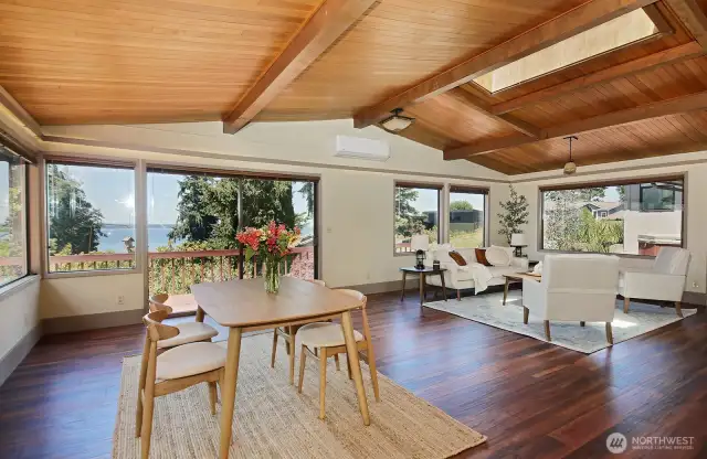 Main Living/Dining area with an abundance of windows, sliding glass doors, new flooring (laminate hardwood) and a mini-split. A skylight too! Your back is to the kitchen.