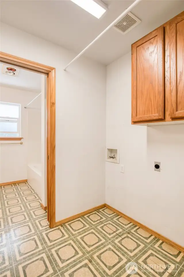 Upstairs laundry room leading to full bath
