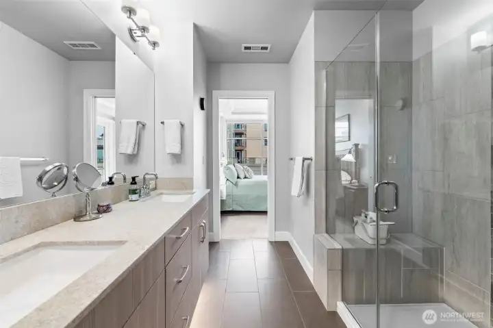 Spa-quality primary bath includes under-lit floating vanity with Quartz counters and dual sinks, custom-tile shower with bench and large walk-in closet with organizers.
