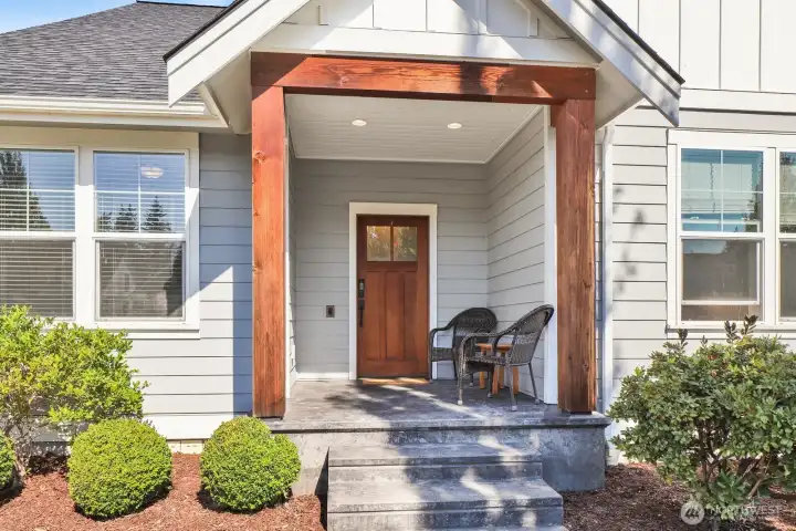The covered porch sets the tone with beautiful stamped concrete and rich fir beams—a perfect Pacific NW touch.