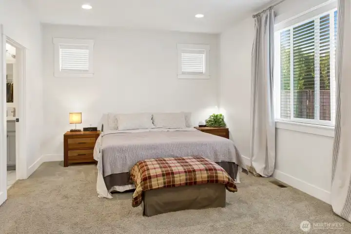 The primary suite is a true retreat, featuring an attached en-suite with a soaking tub, separate shower, enclosed toilet, double sinks, and a spacious walk-in closet.