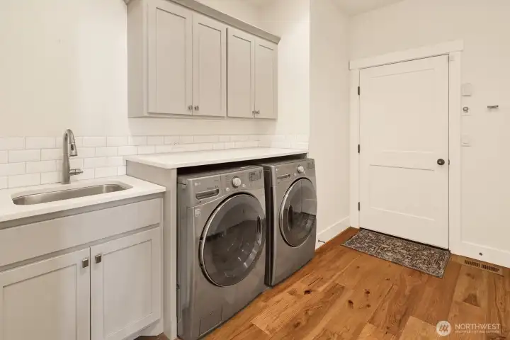 Functional laundry room with storage, folding space, and a sink!