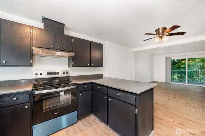 The open-style kitchen, adorned with rich-colored cabinetry & gleaming stainless-steel appliances, is perfectly situated for both practicality & style.