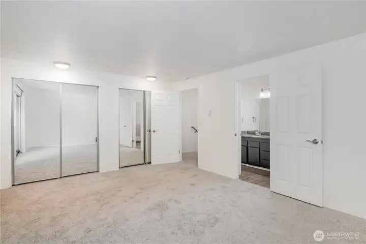 Another view of the primary boasts large mirrored door closets.