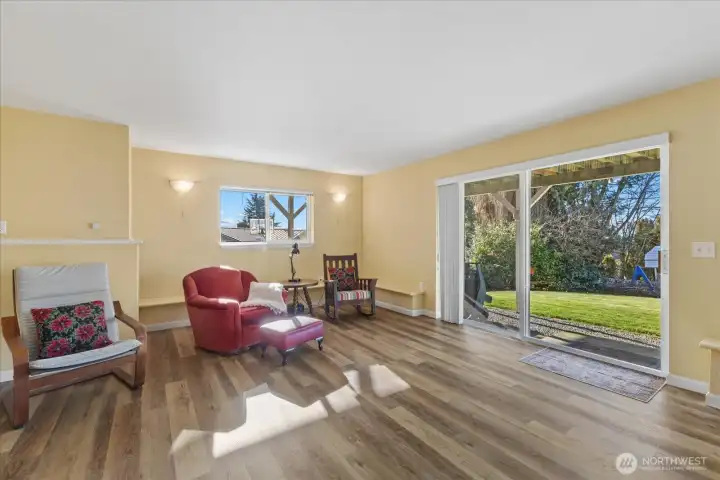 Downstairs sitting area w/ a slider leading out to the large backyard.