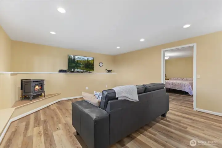 Downstairs family room w/ a freestanding gas stove.
