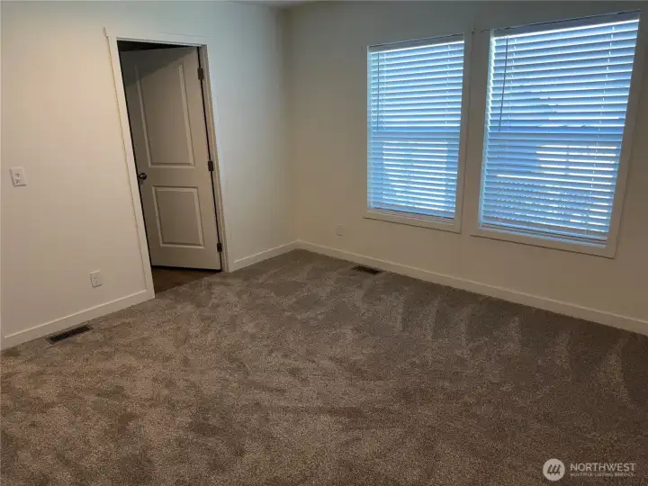 Primary bedroom looking at walk in closet. NOTE: Picture is of a different home w/same floor plan so colors may be different.