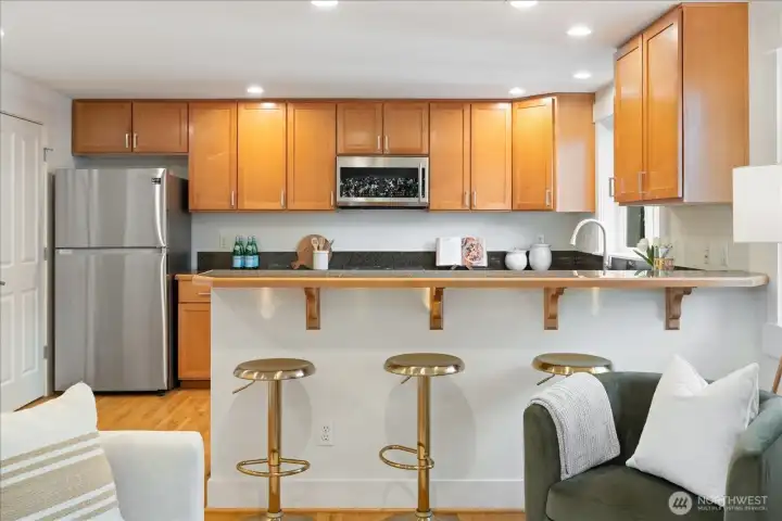 Clean lines, warm cabinetry, and abundant counter seating create an easy flow for everyday living and casual gathering.