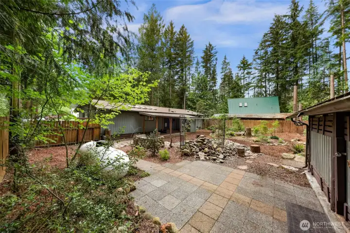 Patio space outside the outbuilding. There is also plenty of firewood for the fire pit and wood stove. Patio space outside the outbuilding. There is also plenty of firewood for the fire pit and wood stove.