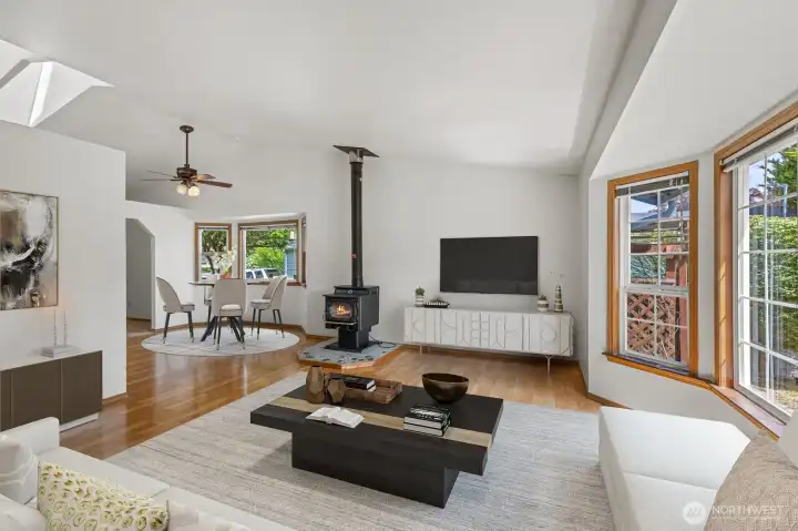 Living room with vaulted ceilings & a cozy wood stove. Virtually staged.