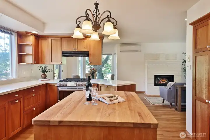 Custom cherry cabinets, butcher block center island and quartz countertops. Both large windows in the kitchen have been replaced since photos. Your back is to the entrance of the main level bedroom and the hallway to the half bath, laundry room & garage.