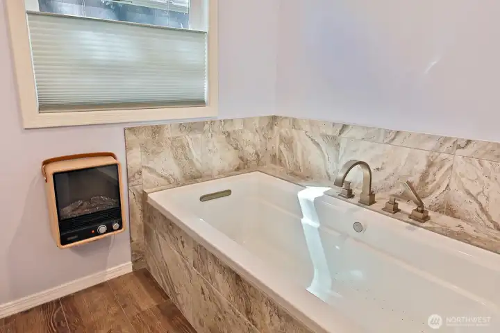 Deep soaking tub, ceramic tile floors and a sweet electric fireplace heater. The window in this bathroom perfectly frames the beautiful Fir tree that stands tall in your backyard.