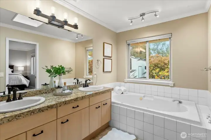 Spacious primary bath featuring a walk-in shower and soaking tub.