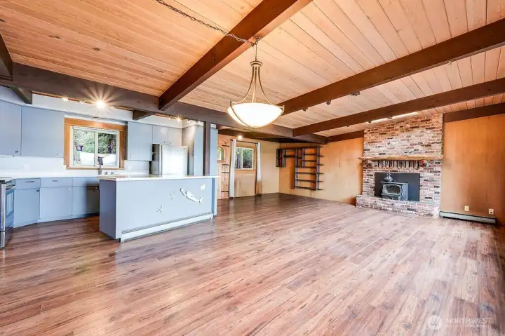 Photo of the main living space. Newer vinyl flooring, 6-yr old roof, new wiring and plumbing throughout.