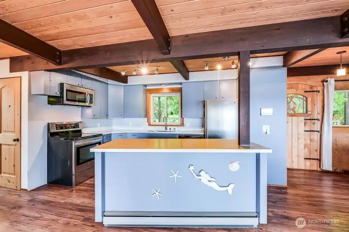 The cabinets were made by the sellers father in 1966 when he built the house. The quartz counter top is one piece and only a few years old.