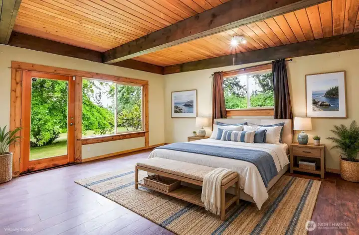 The primary bedroom is spacious with access to the front yard and glorious sunrises and water views.