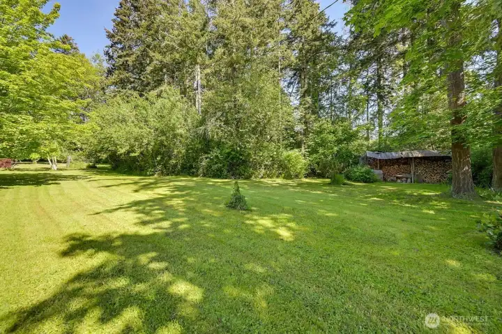 I can see lawn games, tents and campouts and peaceful times in this expansive back yard. Note an old wood shed in the background.