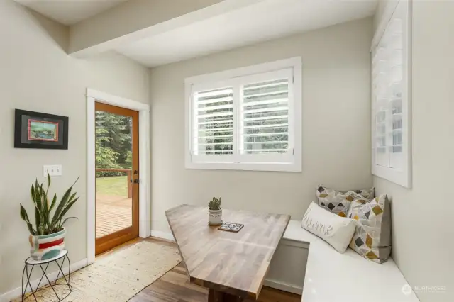 Sunny breakfast nook has a custom table, and access to the rear deck.