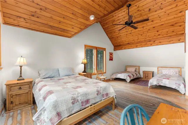 Expansive upstairs bedroom with vaulted tongue-and-groove ceiling—room for guests, family, or a bunkhouse feel