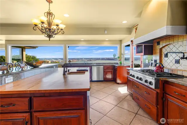 Chef’s dream kitchen boasts a spacious butcher block countertop paired with panoramic views—ideal for both culinary creativity and entertaining.