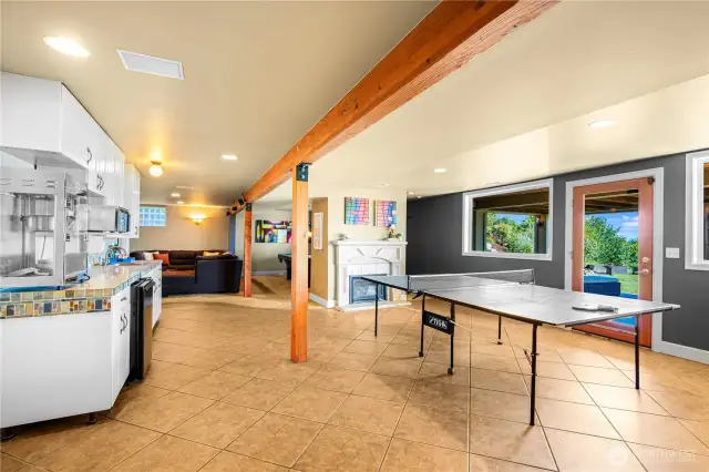 Lower level designed for fun and relaxation, featuring pool and ping pong tables alongside a built-in TV area—perfect for game nights and movie marathons.