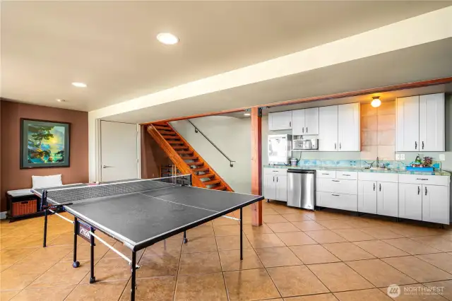 Game area kitchenette stocked with a popcorn machine, cookie warmer, sink, and dishwasher—ideal for family fun and casual entertaining.